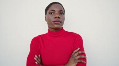 Afrika kökenli Amerikalı kadın, izole edilmiş beyaz arka planda ciddi bir ifadeyle yan tarafa bakıyor.