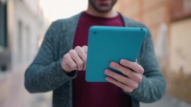 Young bald man smiling confident using touchpad at street