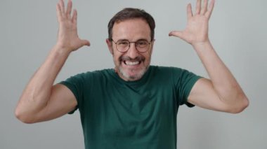 İzole edilmiş beyaz arka planda kazanan yüz ifadesiyle duran orta yaşlı bir adam.