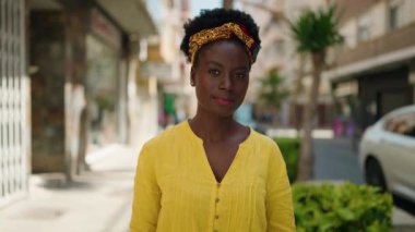 Young african american woman doing spend money symbol with hands at street