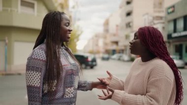 Two african american women smiling confident speaking at street