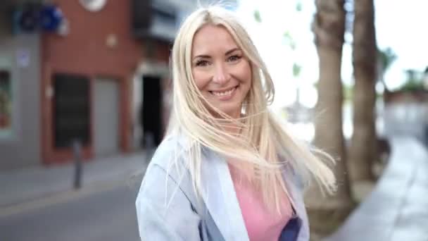 Νεαρή Ξανθιά Γυναίκα Χαμογελά Αυτοπεποίθηση Γυρίζει Γύρω Από Τον Εαυτό — Αρχείο Βίντεο