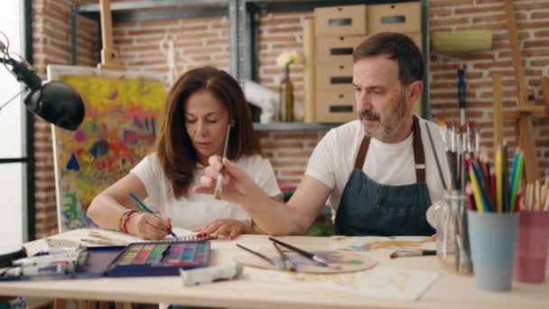 男と女のカップルはノートに絵を描くでアートスタジオ — ストック動画