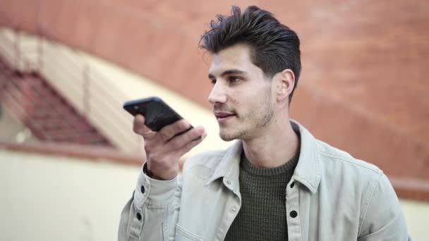 年轻人面带微笑 自信地在街上用智能手机发送语音讯息 — 图库视频影像