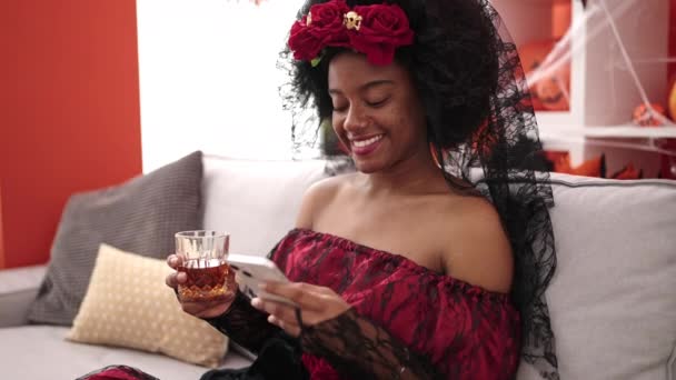 African American Woman Wearing Katrina Costume Using Smartphone Drinking Whisky — Αρχείο Βίντεο