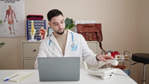Jeune Homme Arabe Médecin Utilisant Ordinateur Portable Parlant Téléphone Clinique — Video