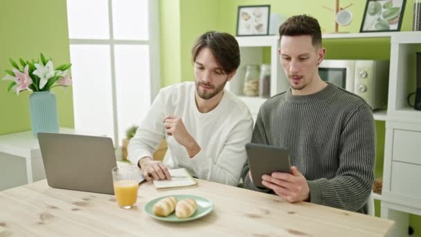 Δύο Άνδρες Ζευγάρι Λαμβάνοντας Πρωινό Χρησιμοποιώντας Touchpad Και Laptop Γράφοντας — Αρχείο Βίντεο
