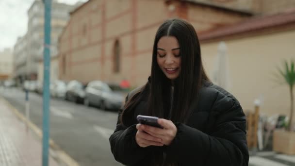 Junge Hispanische Frau Lächelt Selbstbewusst Mit Smartphone Auf Der Straße — Stockvideo
