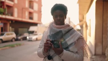 Young african american woman photographer using professional camera at street
