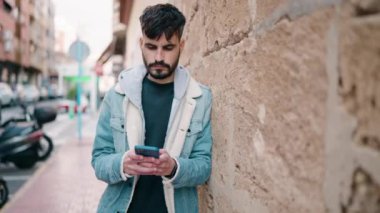 Sokakta akıllı telefon kullanan, kendine güvenen genç bir İspanyol.
