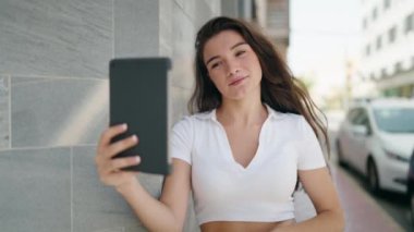 Young hispanic woman smiling confident having video call at street