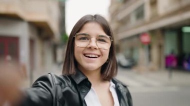 Young hispanic woman smiling confident having video call at street