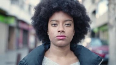 Sokakta ciddi bir ifadeyle yürüyen Afrikalı Amerikalı kadın.