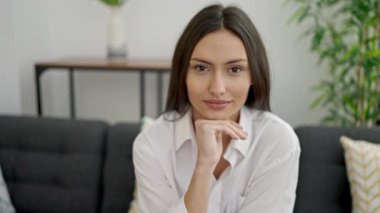 Evdeki kanepede oturan kendine güvenen güzel İspanyol kadın.