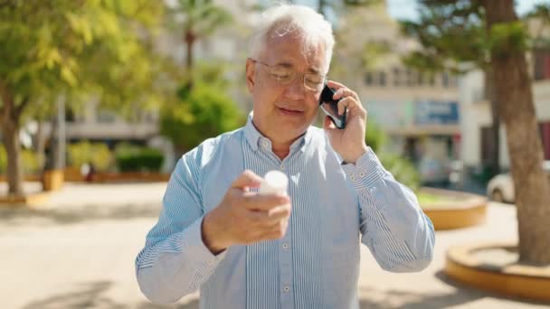 Uomo Anziano Parlando Sullo Smartphone Possesso Pillole Parco — Video Stock