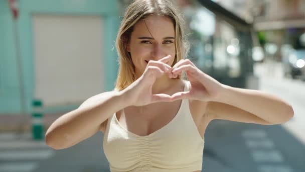 Young Blonde Woman Smiling Confident Doing Heart Gesture Hands Street — Stock video