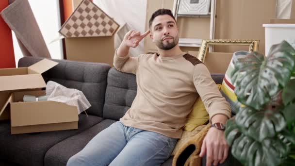 Jovem Árabe Homem Sentado Sofá Esticando Braços Nova Casa — Vídeo de Stock