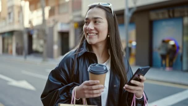 Ung Smuk Spansktalende Kvinde Ved Hjælp Smartphone Holder Indkøbsposer Kaffe – Stock-video