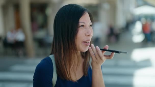 若いアジアの女性が自信を持って話して笑顔コーヒーショップテラスでスマートフォン — ストック動画