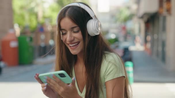 Genç Güzel Spanyol Kadın Gülümsüyor Sokakta Akıllı Telefondan Videolar Izliyor — Stok video