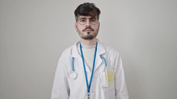 年轻的惊慌失措的医生面带微笑 自信地站在孤独的白色背景之上 — 图库视频影像