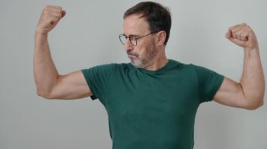 Middle age man doing strong gesture with arms over isolated white background
