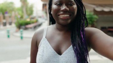 Afro-Amerikalı bir kadın kahvecinin terasında dans ederken kendine güveniyor.