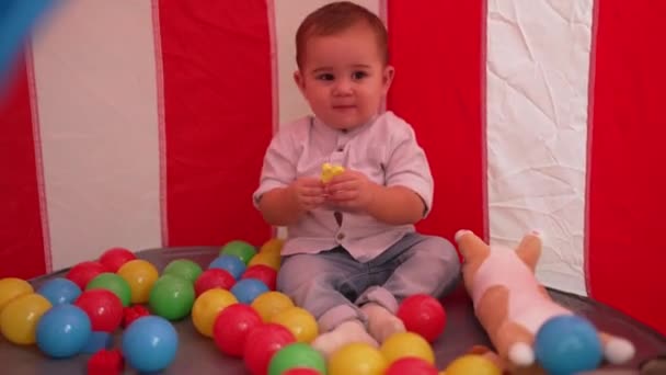 愛らしい幼児遊びますおもちゃで座っているサーカステントの中にホーム — ストック動画