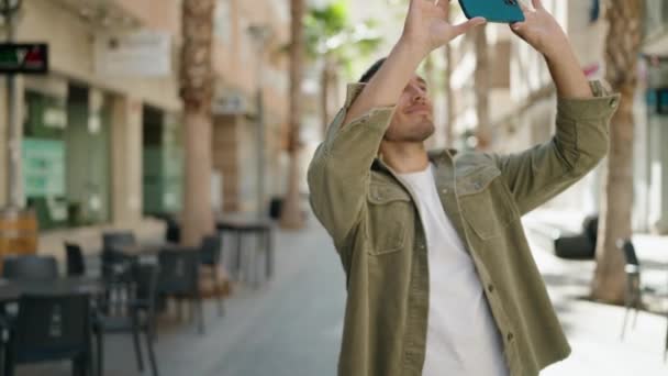 Νεαρός Ισπανόφωνος Άντρας Κάνει Φωτογραφία Smartphone Περπατώντας Στο Δρόμο — Αρχείο Βίντεο