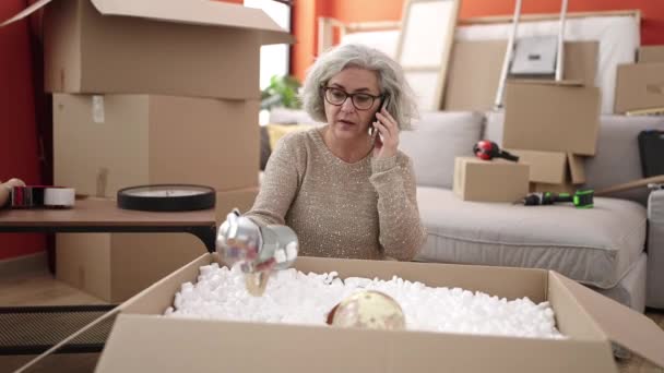 Middle Age Woman Grey Hair Talking Smartphone Unpacking Cardboard Box — Stockvideo
