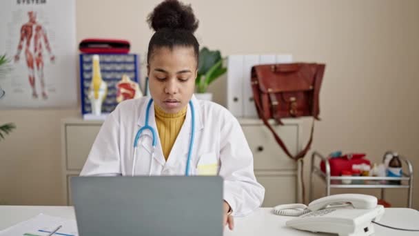 若いアフリカ系アメリカ人女性の医師が診療所でラップトップを使って — ストック動画