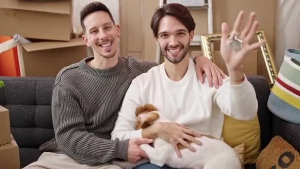 Zwei Männer Mit Schlüssel Sitzen Mit Hund Auf Sofa Neuen — Stockvideo