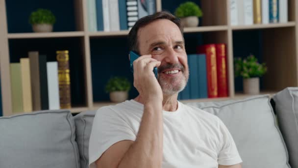 Middelbare Leeftijd Man Aan Het Praten Smartphone Zittend Bank Thuis — Stockvideo