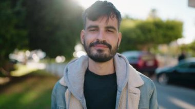 Parkta kendinden emin gülümseyen İspanyol genç adam.