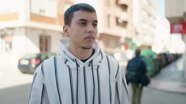 Sokakta kendine güvenen genç adam gülümsüyor