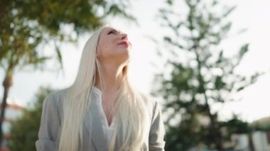 Young blonde woman executive smiling confident standing at park