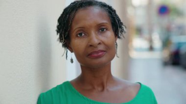 Middle age african american woman standing with serious expression at street