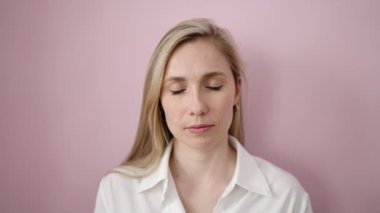 Young blonde woman smiling confident standing over isolated pink background