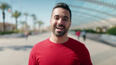 Genç İspanyol adam gülümsüyor Sokakta kendinden emin konuşuyor