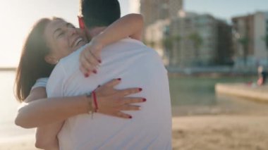 Man and woman couple hugging each other standing at beach