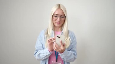 Young blonde woman smiling confident using smartphone over isolated white background