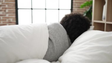 Afro-Amerikalı kadın yatakta uzanıyor. Yatak odasında uyuyor.