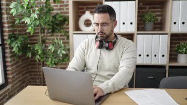 Genç İspanyol iş adamı ofiste dans eden müzik dinliyor.