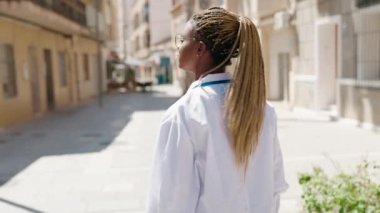 African american woman doctor smiling confident standing with arms crossed gesture at street
