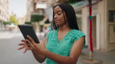 African american woman smiling confident using touchpad at street