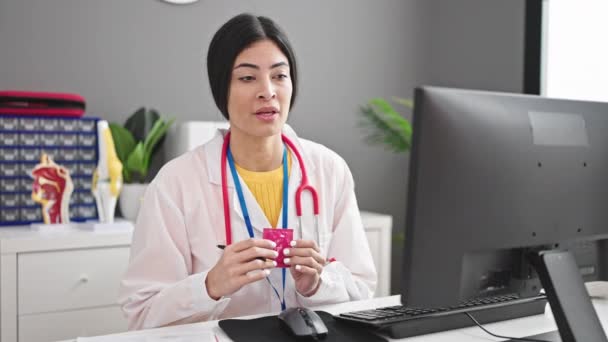 Young Beautiful Hispanic Woman Doctor Writing Medical Report Holding Condom — Stock Video