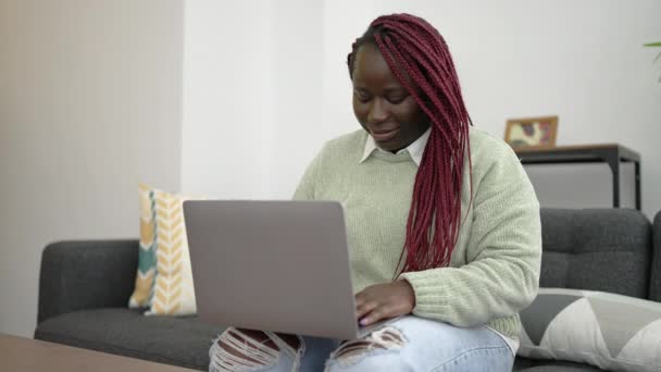 Afrikansk Kvinna Med Flätat Hår Med Laptop Sitter Soffan Hemma — Stockvideo