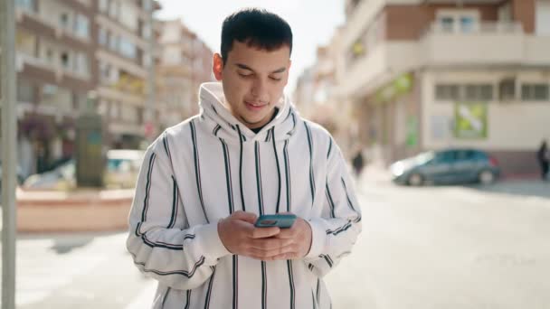 Молодой Человек Уверенно Улыбается Используя Смартфон Улице — стоковое видео