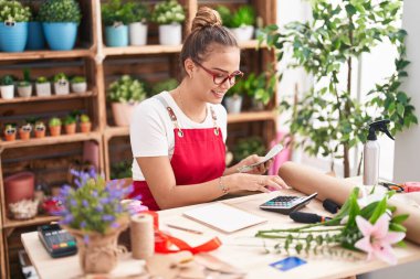 Çiçekçiye gülen güzel İspanyol kadın çiçekçiye para sayıyor.