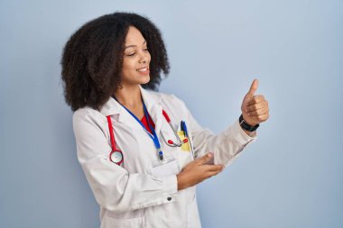 Genç Afro-Amerikan kadın doktor üniforması ve steteskop giyiyor. Gururlu görünüyor, gülümsüyor. 